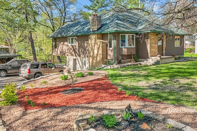view of front of property featuring a chimney, asphalt driveway, and a front yard