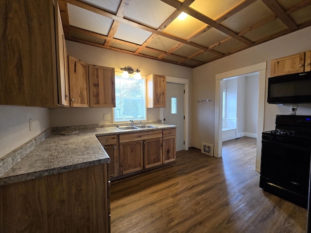 kitchen with black appliances, dark hardwood / wood-style floors, and sink