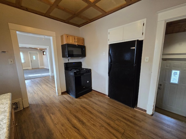 kitchen featuring dark wood-type flooring, white cabinets, and black appliances