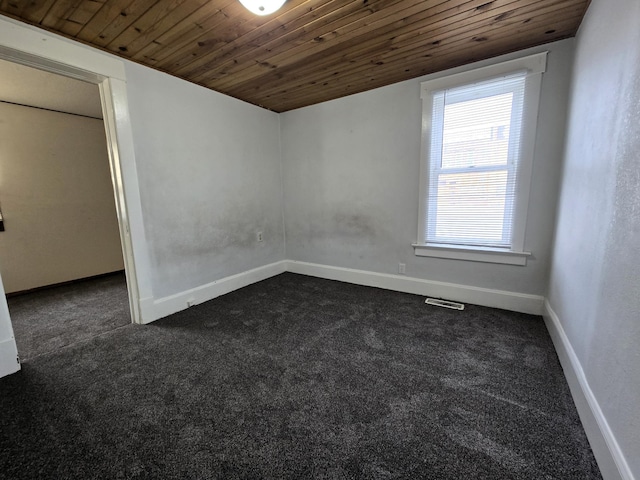 unfurnished room with wood ceiling and dark carpet