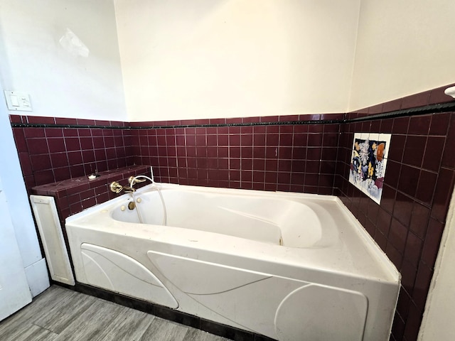 bathroom with a tub and hardwood / wood-style floors