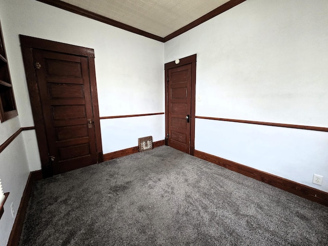 unfurnished room with ornamental molding and carpet floors