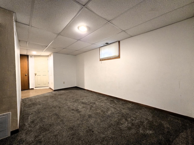 basement featuring a paneled ceiling and carpet flooring