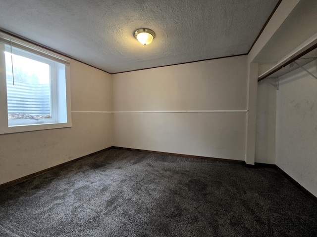 carpeted empty room featuring a textured ceiling