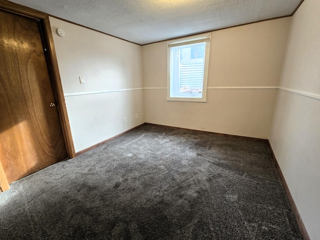 carpeted spare room with a textured ceiling