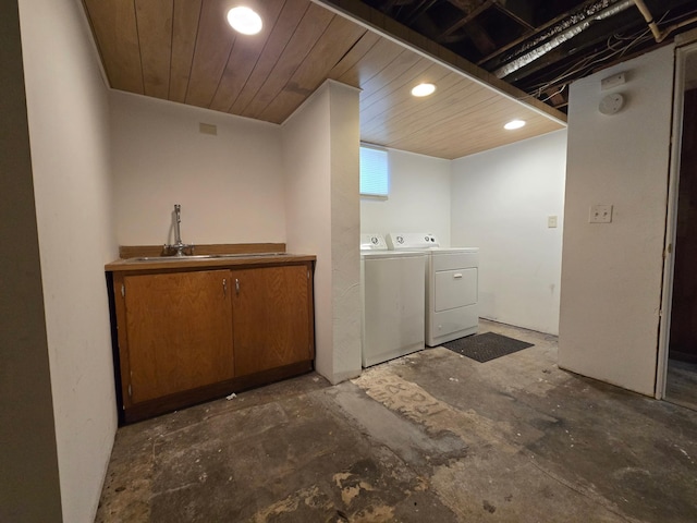 washroom with wood ceiling, washer and clothes dryer, and sink