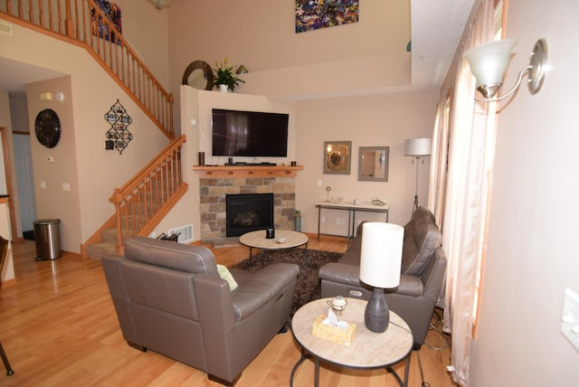 living room featuring light wood-type flooring and a fireplace