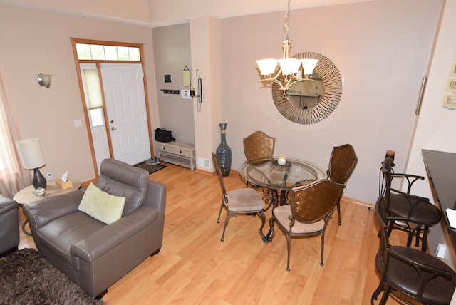 dining space featuring an inviting chandelier and light hardwood / wood-style flooring