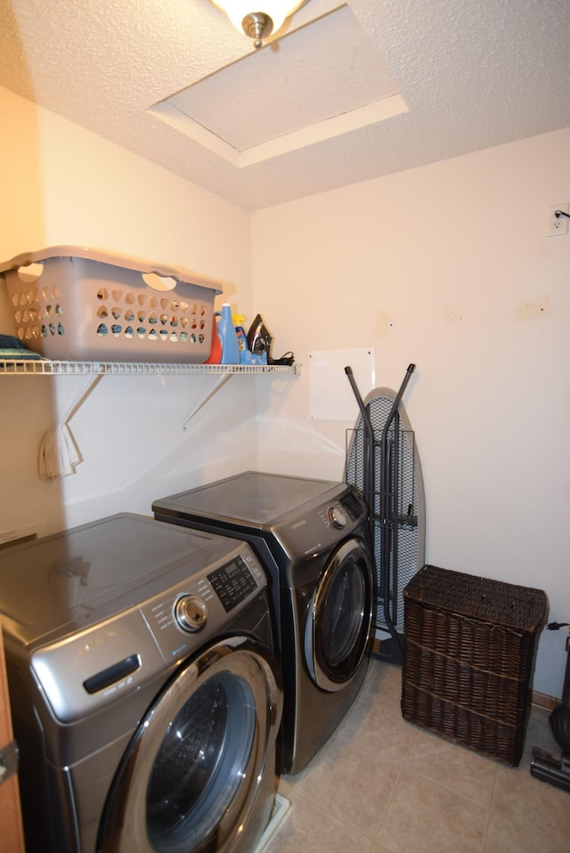 laundry area featuring a textured ceiling and washing machine and dryer