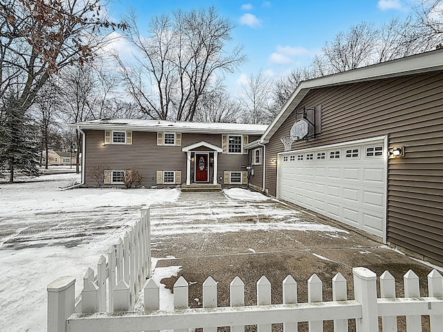 raised ranch featuring entry steps, driveway, and fence