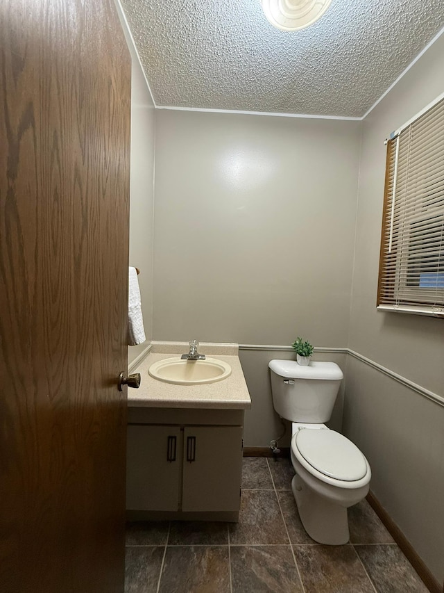 619 10th St, Montevideo, MN 56265 - half bath with toilet, vanity, a textured ceiling, baseboards, and tile patterned flooring