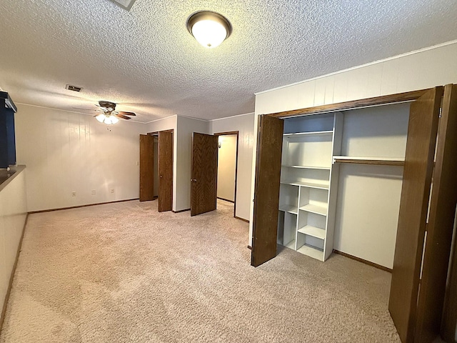 619 10th St, Montevideo, MN 56265 - unfurnished bedroom with multiple closets, light carpet, a textured ceiling, and baseboards
