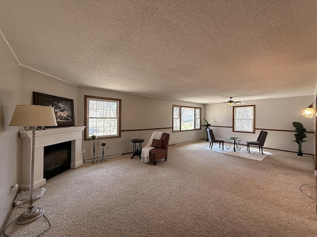 619 10th St, Montevideo, MN 56265 - living area featuring a textured ceiling, carpet, a fireplace, a ceiling fan, and baseboards