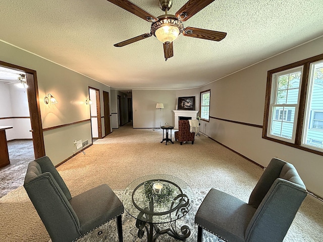 619 10th St, Montevideo, MN 56265 - sitting room with a ceiling fan, light colored carpet, a fireplace, a textured ceiling, and baseboards