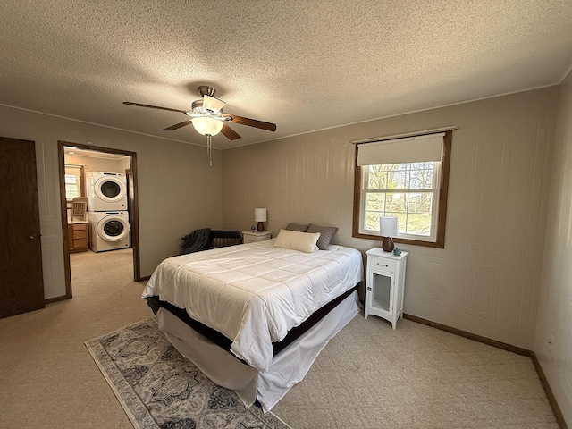 619 10th St, Montevideo, MN 56265 - bedroom with stacked washer / drying machine, a textured ceiling, light colored carpet, and ceiling fan