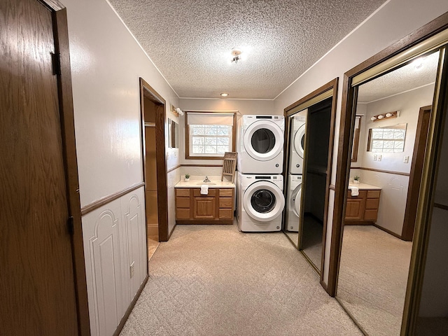 619 10th St, Montevideo, MN 56265 - washroom with stacked washer / drying machine, a textured ceiling, cabinet space, and light colored carpet
