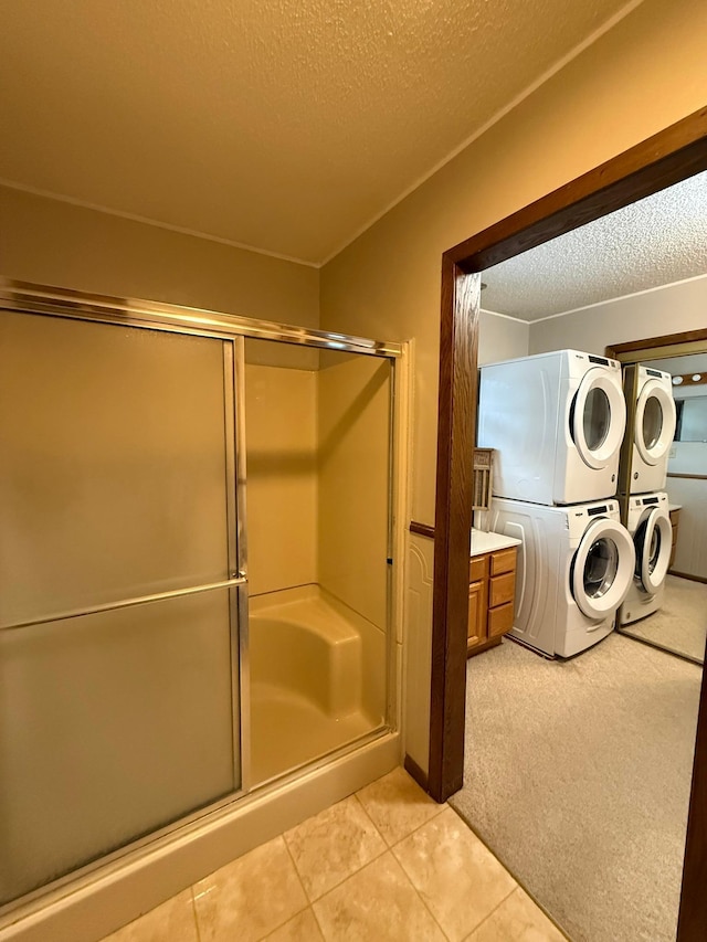 619 10th St, Montevideo, MN 56265 - full bathroom with stacked washer and clothes dryer, a textured ceiling, a stall shower, and tile patterned flooring