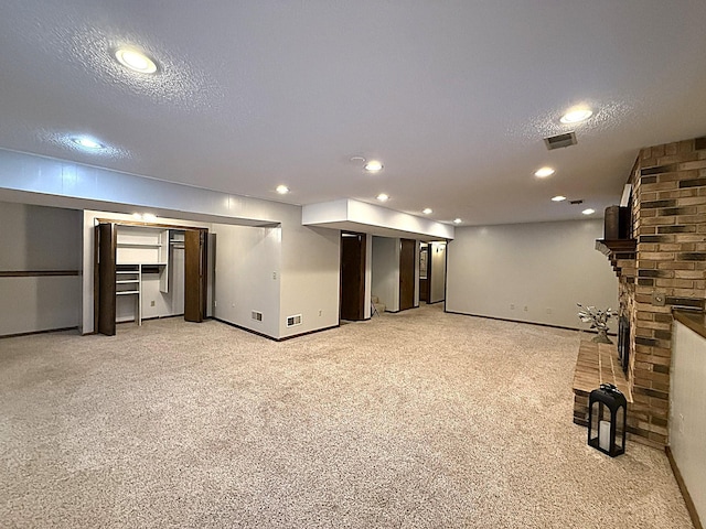 619 10th St, Montevideo, MN 56265 - finished below grade area with light carpet, a textured ceiling, recessed lighting, baseboards, and a fireplace