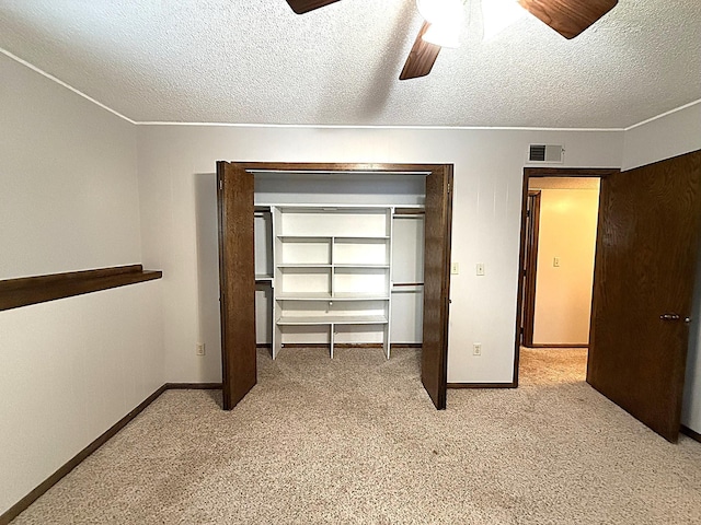 619 10th St, Montevideo, MN 56265 - unfurnished bedroom featuring light colored carpet, baseboards, a textured ceiling, ceiling fan, and a closet