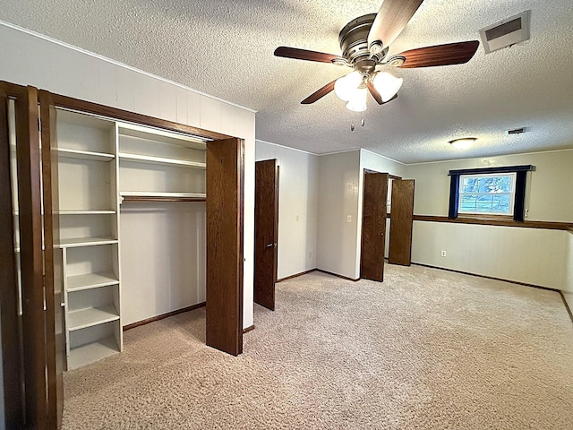 619 10th St, Montevideo, MN 56265 - unfurnished bedroom featuring light carpet, a textured ceiling, a closet, ceiling fan, and wood walls