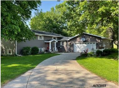 619 10th St, Montevideo, MN 56265 - view of front of house featuring concrete driveway, a front lawn, and an attached garage