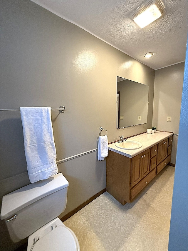 619 10th St, Montevideo, MN 56265 - bathroom with toilet, vanity, a textured ceiling, and baseboards