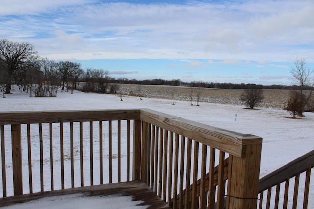 snow covered deck with a rural view