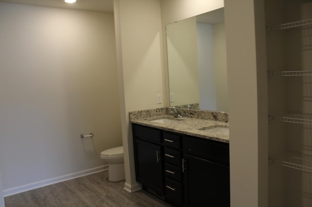 bathroom with hardwood / wood-style flooring, toilet, and vanity