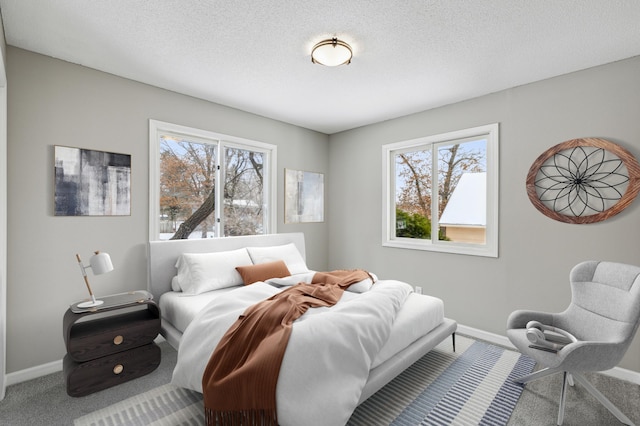 bedroom featuring a textured ceiling and carpet flooring