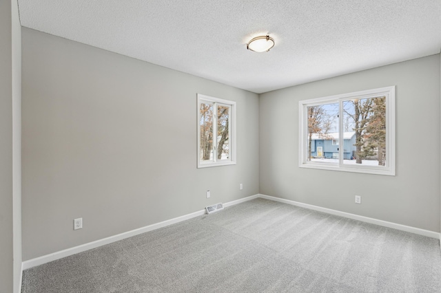 carpeted spare room featuring a textured ceiling