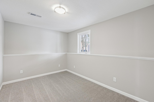 empty room with carpet floors and a textured ceiling