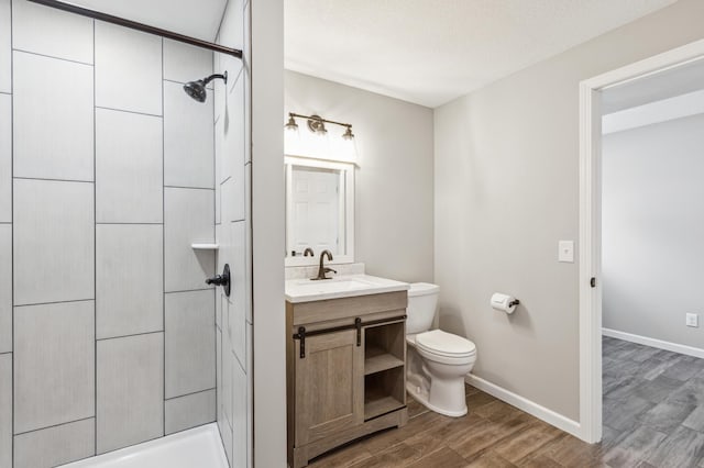 bathroom with a shower, hardwood / wood-style flooring, a textured ceiling, toilet, and vanity