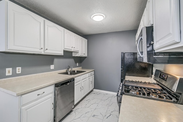 kitchen with a textured ceiling, sink, stainless steel appliances, and white cabinetry