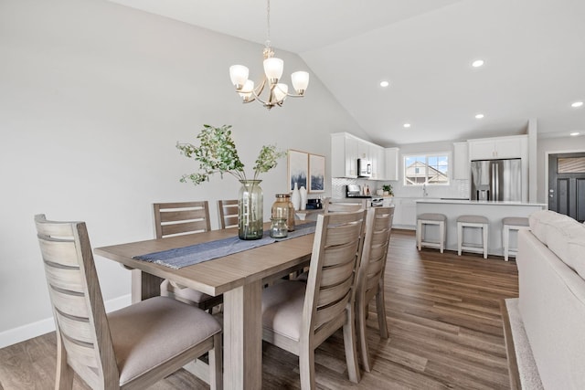 dining area with vaulted ceiling, dark hardwood / wood-style flooring, and an inviting chandelier