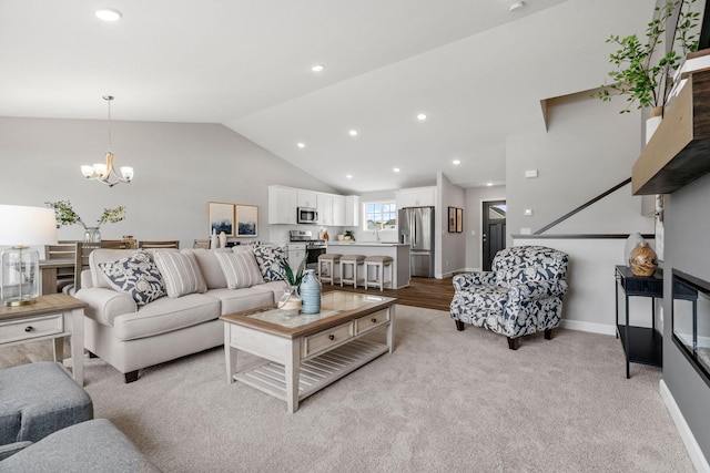 living room with sink, light carpet, lofted ceiling, and an inviting chandelier