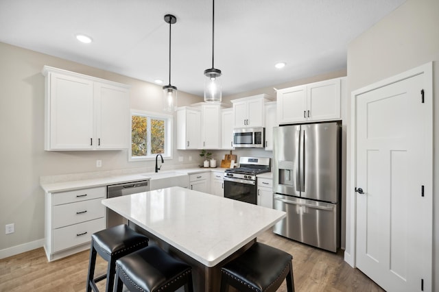 kitchen with white cabinetry, pendant lighting, and stainless steel appliances