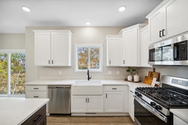 kitchen featuring white cabinetry, appliances with stainless steel finishes, sink, and wood-type flooring