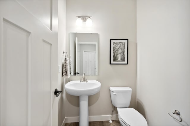 bathroom with hardwood / wood-style flooring and toilet