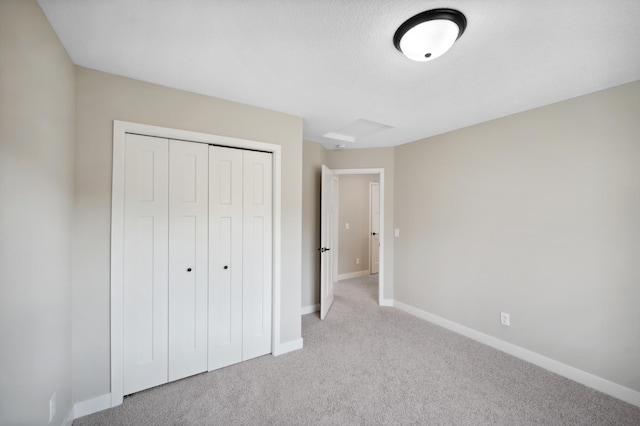 unfurnished bedroom featuring light carpet and a closet