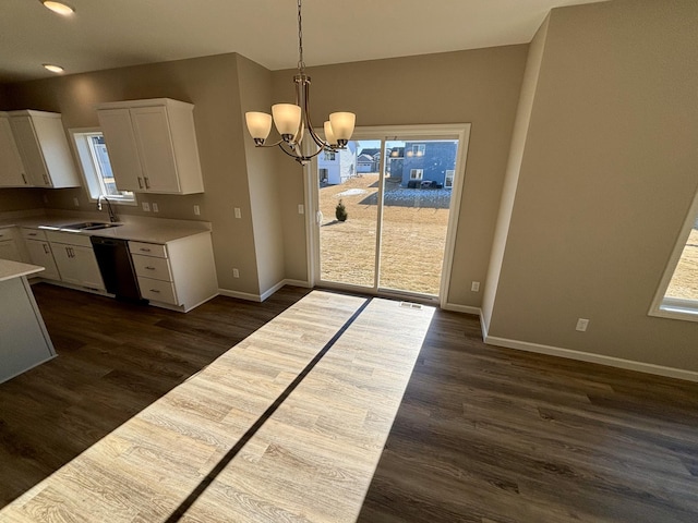 kitchen with pendant lighting, sink, dishwasher, white cabinetry, and dark hardwood / wood-style flooring