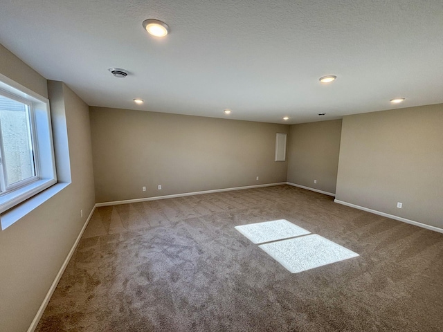 carpeted empty room with a textured ceiling