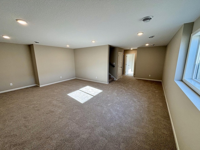 spare room with carpet and a textured ceiling