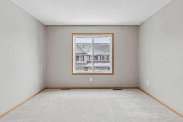 carpeted empty room with a textured ceiling