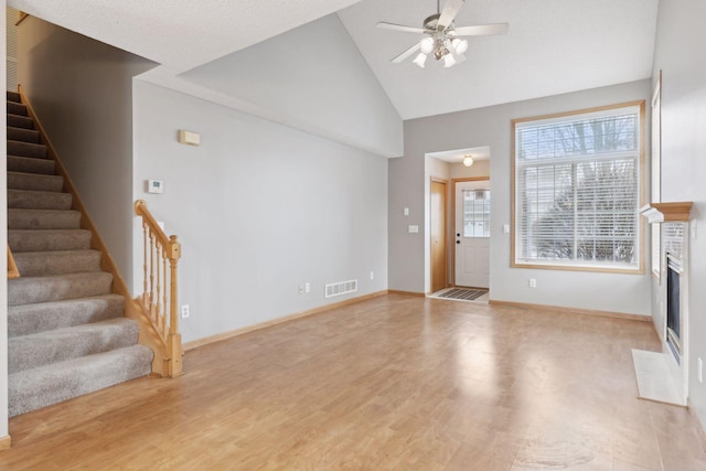 unfurnished living room with light hardwood / wood-style flooring, high vaulted ceiling, and ceiling fan