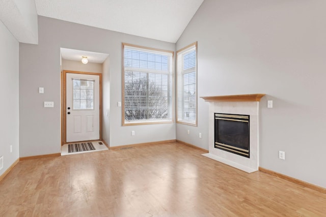 unfurnished living room with light wood-type flooring and vaulted ceiling