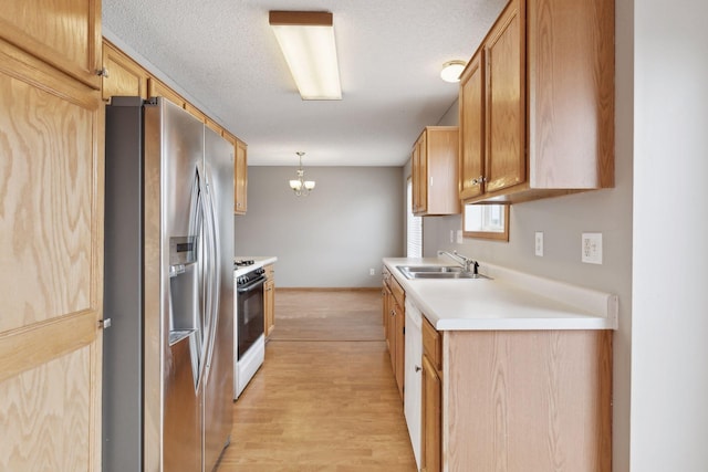 kitchen featuring decorative light fixtures, white range with gas cooktop, sink, stainless steel fridge with ice dispenser, and light wood-type flooring