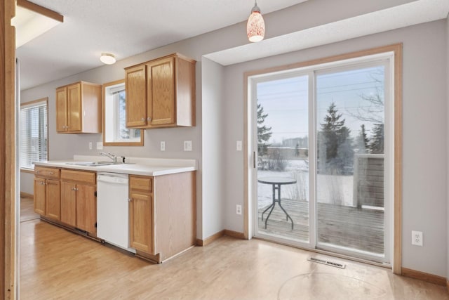 kitchen with sink, dishwasher, light hardwood / wood-style flooring, and pendant lighting