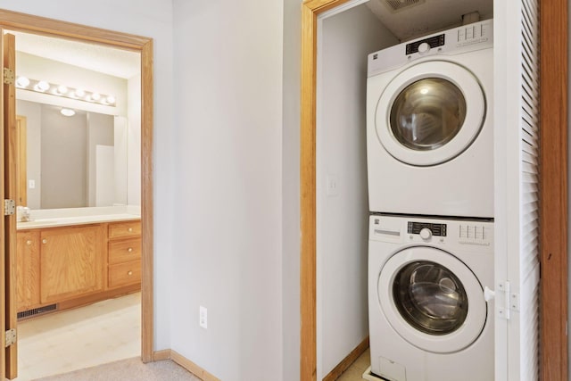 clothes washing area with sink and stacked washing maching and dryer