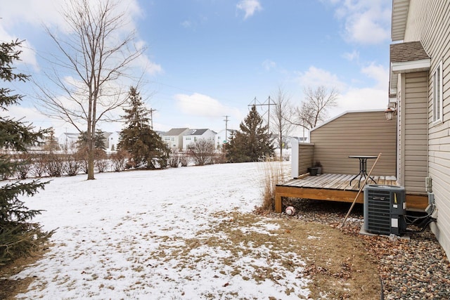 snowy yard with a deck and central AC unit