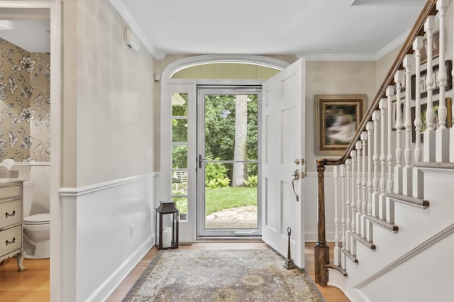 foyer entrance featuring crown molding and light hardwood / wood-style floors